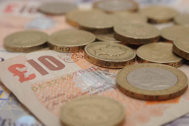 A selection of one pound coins, two pound coins and bank notes
