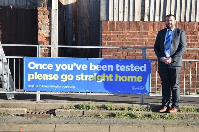 Coun Matthew Boles with one of the new signs the council has installed