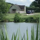 The Skylark Lodge at Brook Meadow viewed from across the campsite's five-acre fishing lake