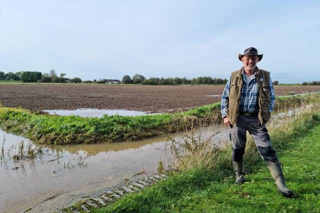 Stewart Peltell, of FLAG, by a dyke still full of water after overtopping and flooding a Wainfleet home for the second time.