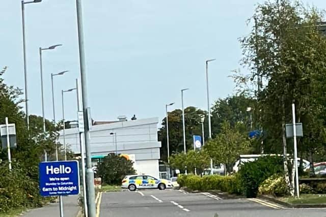 Police stopping travellers entering the back of Tesco car park.