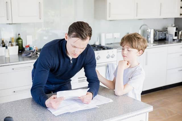 Man searching through paperwork while boy looks on - copyright SafeKeep