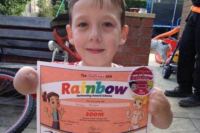 Proud Harvey with one of his earliest swimming certificates as a boy.