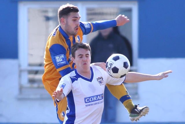 Greg Taylor battles for the ball with Barrow's Adam Boyes.