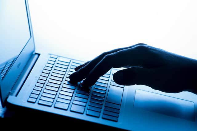 A woman's hand presses a key of a laptop keyboard.