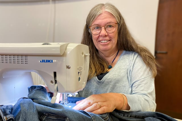 Sandra Burniston repairs a pair jeans for a member of the public with some free motion darning. 
Photo: Chris Frear