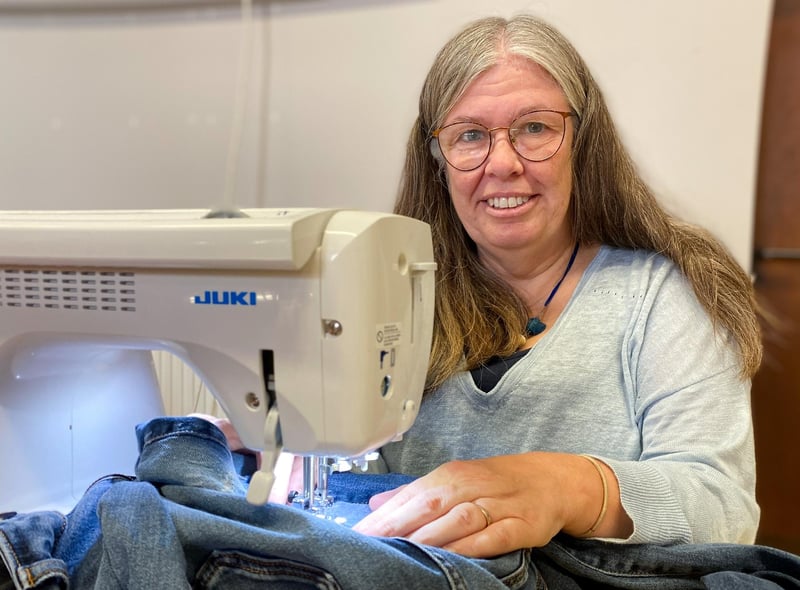 Sandra Burniston repairs a pair jeans for a member of the public with some free motion darning. 
Photo: Chris Frear