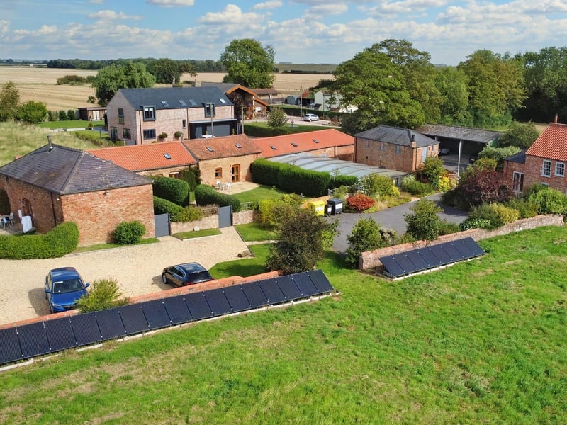 An aerial view of part of the grounds, with the bank of solar panels in the foreground.
