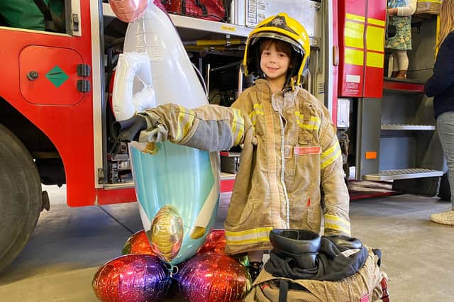 Mya Selby, 5, tries out a Firefighters jacket and helmet.