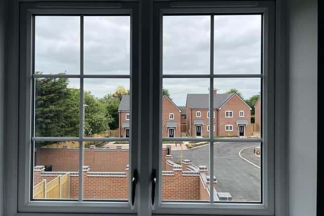 A window frames a shot looking out to homes on the development.