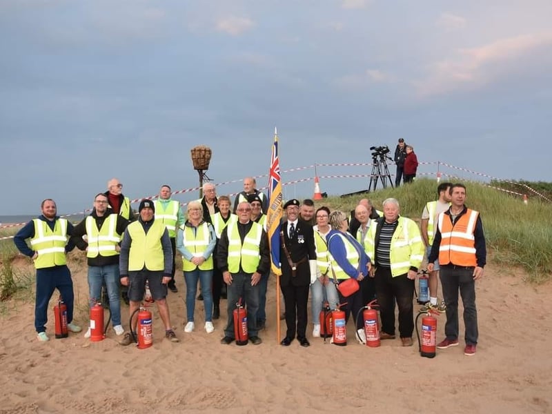 Volunteers with Kevin Woolley, Standard Bearer for the Skegness branch of the Royal Britrish Legion, at the beacon lighting.