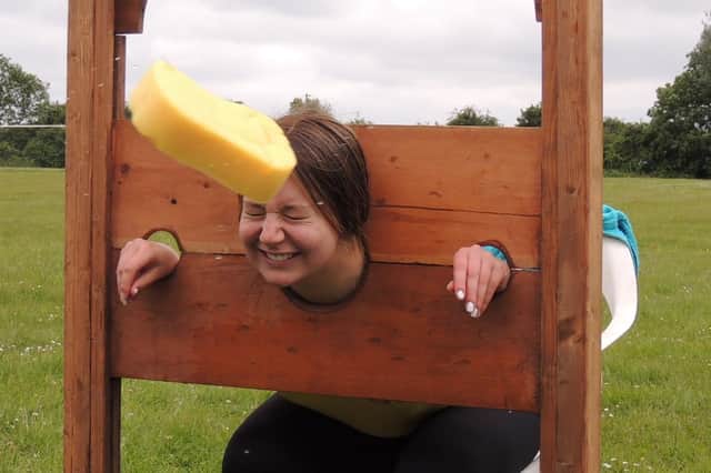 A direct hit! Billinghay pool lifeguard Emily Farrow in the stocks at the village jubilee fund day on the playing field.