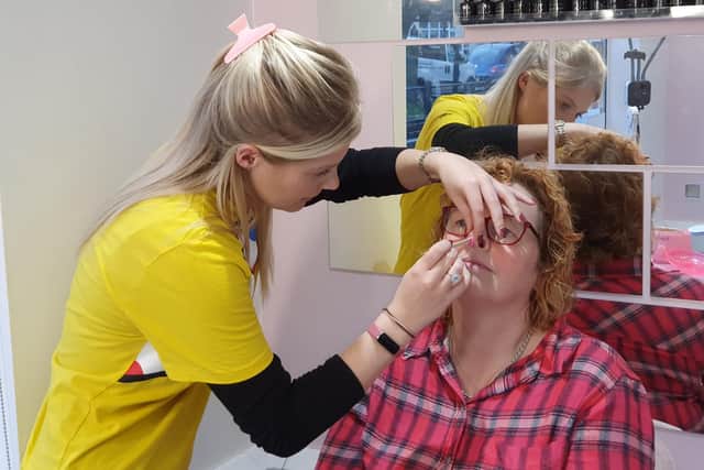 Sophie Hare applies the nasal wax to customer Andrea Kirk.