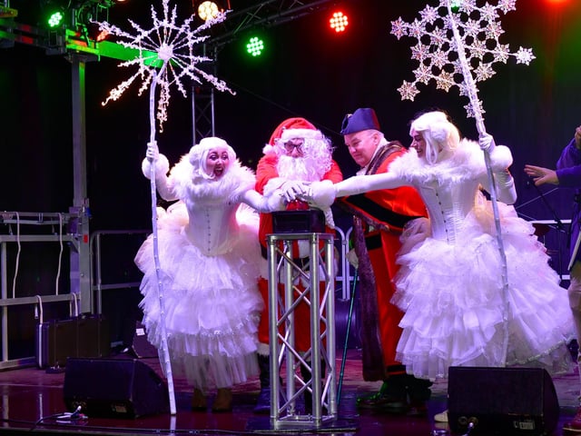 The button is pushed to turn on the town's Christmas illuminations.