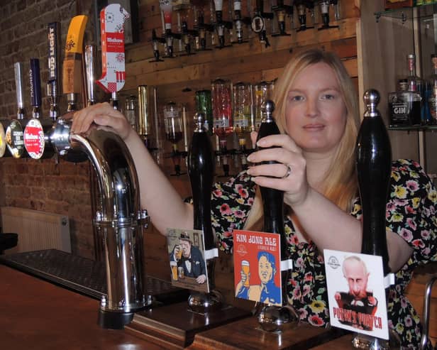 Catherine Mitchell with their range of beers including Putin's Porter and Kim Jong Ale.