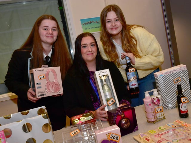 On the raffle stand, Lilly Shinn, 16, staff member Jessica Woods, and Jasmine Epton, 15.