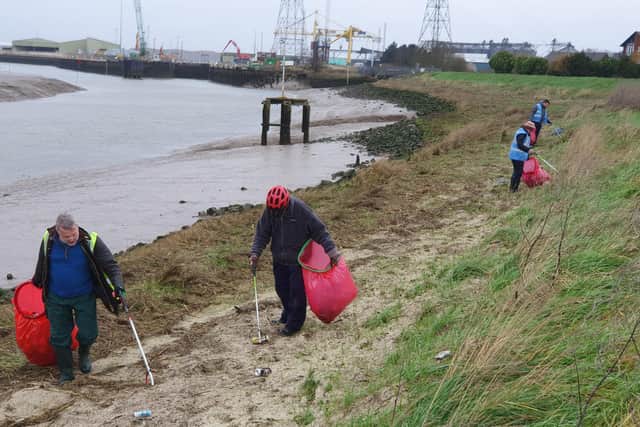 The volunteers endured wet and muddy conditions to collect litter from the river bank area.