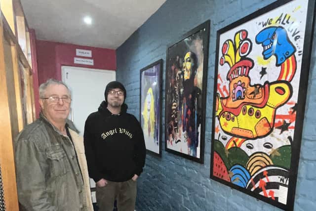 Ross Ellis of Old Nick's Tavern (left) with artist Alfred Natcho and some of his art in the pub.