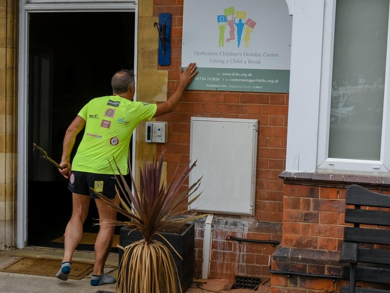 Greg touches the sign at Derbyshire Children's Holiday Centre in Skegness, marking the end point of his epic challenge.