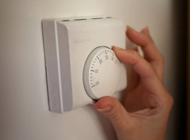 <p>Undated file photo of a person using a central heating thermostat.</p>