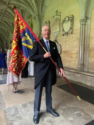 Francis Dymoke with the Royal Standard at the King's Coronation this year.