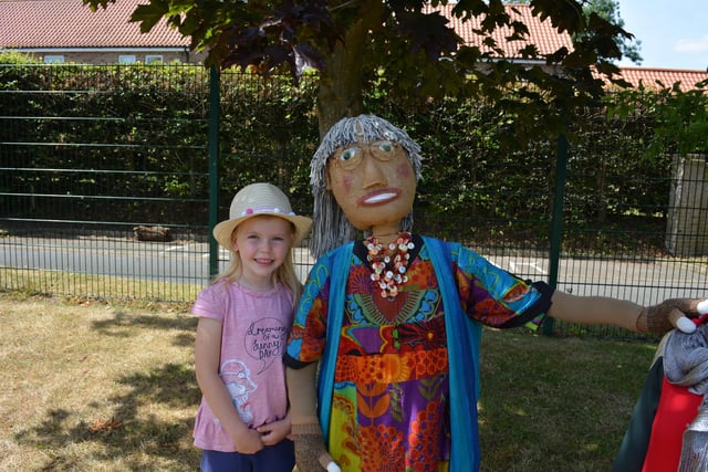 Edie Hewson (5) with one of the colourful scarecrows in the school grounds