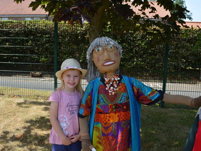 Edie Hewson (5) with one of the colourful scarecrows in the school grounds