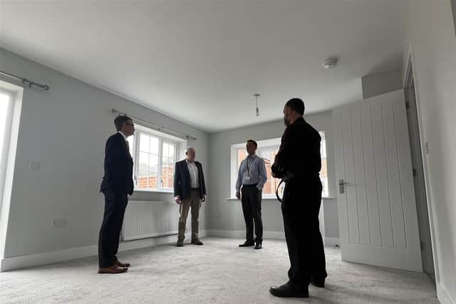 A group stands inside the lounge of one of the new homes.