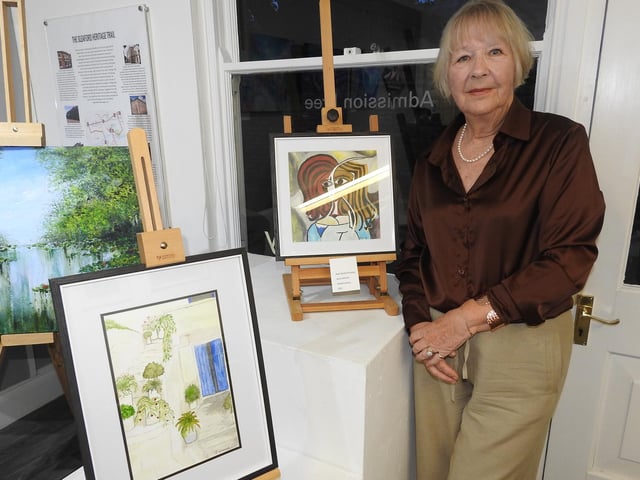 Gallery volunteer Jane Winter with some of her work on display, including one called 'Not Quite Picasso'.