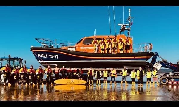 RNLI lifeguards (right) join RNLI volunteer lifeboat crews for a training operation.