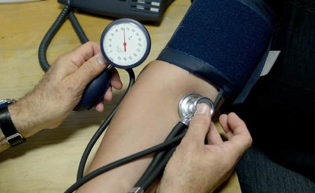 Dr Laurence Buckman checks a patient's blood pressure in his practice room at Temple Fortune Health Centre GP Practice near Golders Green, London.