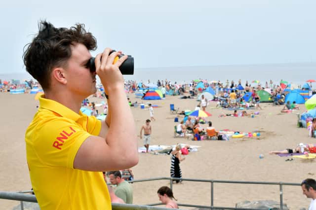 RNLI lifeguard Ethan Scott keeping watch over Skegness  beach