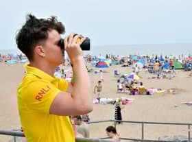 RNLI lifeguard Ethan Scott keeping watch over Skegness  beach