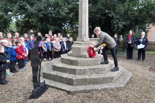 A Friskney All Saint Primary School pupil lays a poppy wreath at the village war memorial.