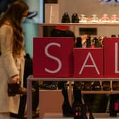 A customer shops for discounted shoes. (Photo by Artur Widak/NurPhoto via Getty Images)