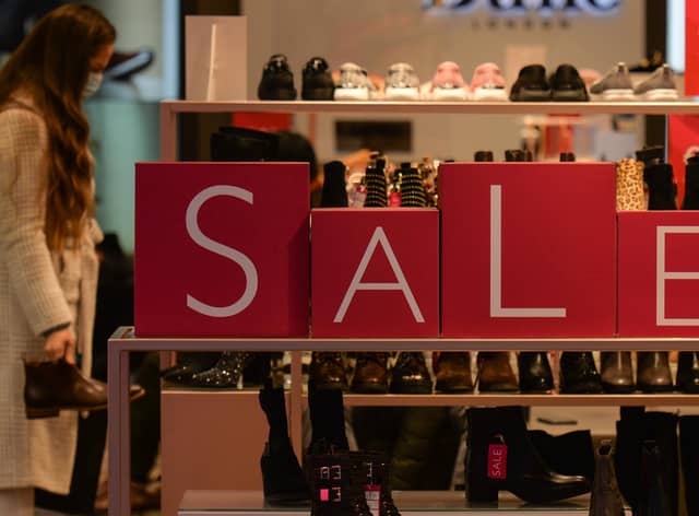 A customer shops for discounted shoes. (Photo by Artur Widak/NurPhoto via Getty Images)