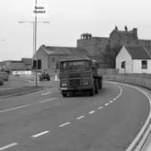 A cyclist with a child on board takes a trip down John Adams Way on its opening day in May 1978. On the right, a road sign reads John Adams Way, but the road would still be called ‘the inner relief road’ in the press for months.