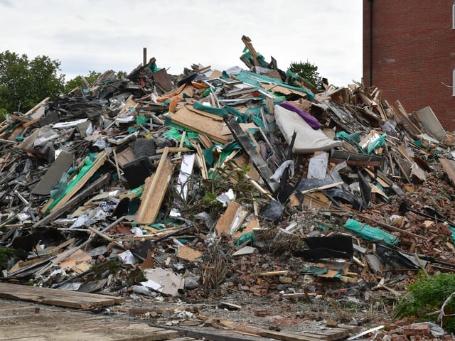 A mattress stands out among the rubble from the demolished building.