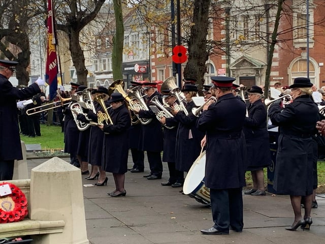 A brass band plays 'The Last Post' at Boston war memorial before a silence is held.