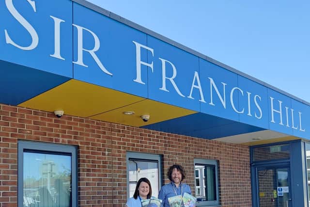 Dr Rob McElroy delivering comics to Miss Bibby, assistant head at The Sir Francis Hill Community Primary School