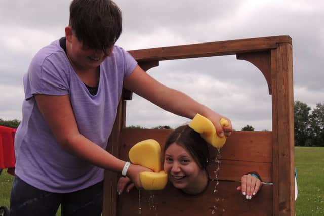 Billinghay pool lifeguard Emily Farrow getting a drenching in the stocks from Ellis Gardner at the village's jubilee fun day.