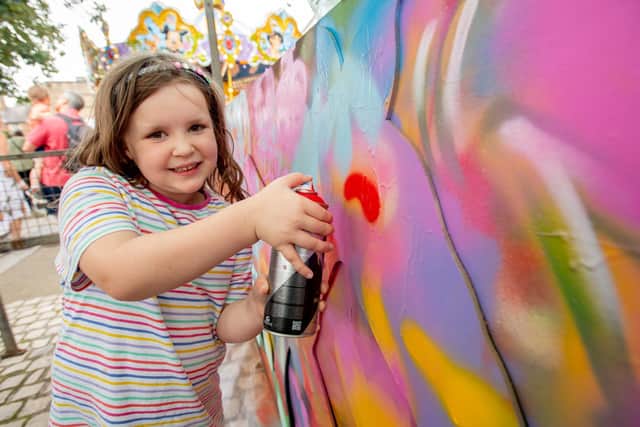Emily Raithby-Veall, 6, having a go at ImageSkool's mural.
