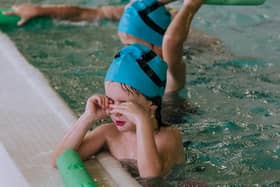 Children taking part in a swimming lesson.