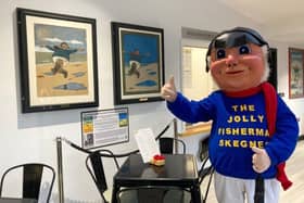 Jolly the Fisherman mascot with the two John Hassall poster paintings, before they were sent off for conservation work.