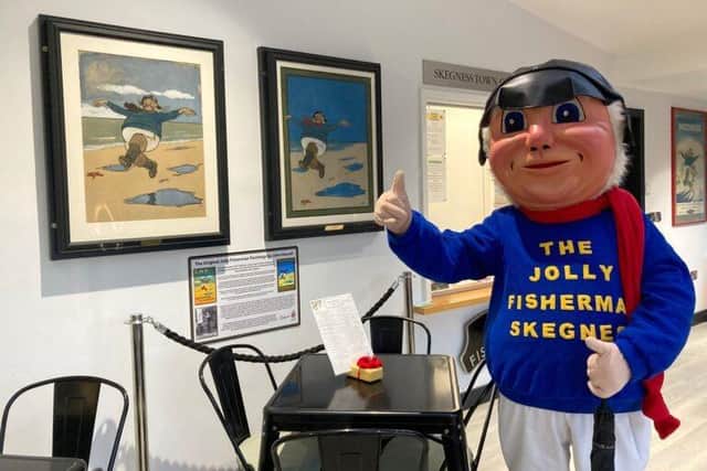 Jolly the Fisherman mascot with the two John Hassall poster paintings, before they were sent off for conservation work.