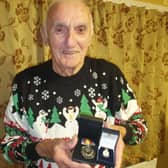 John with his Nuclear Test Medal and Armed Services badge.