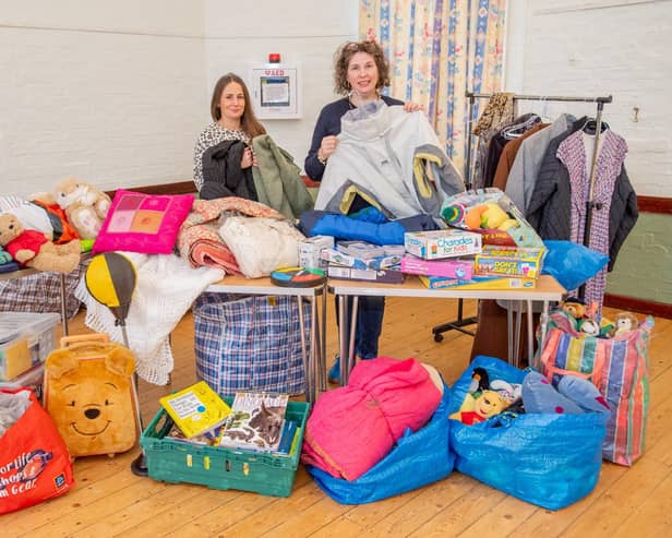 Nancy Benilde, volunteer and Community Larder organiser Isabel Forrester sort through the donated clothes.