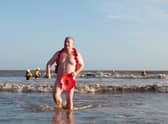 Steve Atherton emerges from the sea at the Mablethorpe Big Dip in his distinctive poppy ensemble.