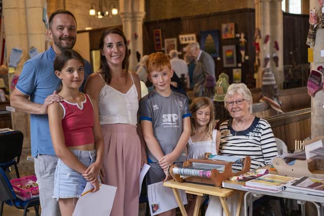 Edna Camm, 90, with her granddaughter and great grandchildren as she weaves a scarf on a rigid heddle loom. Photo: Holly Parkinson