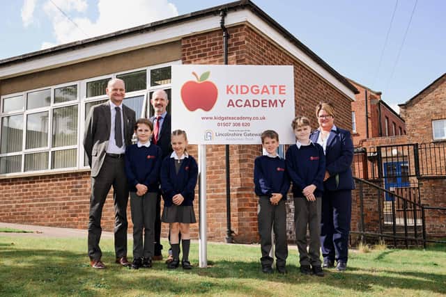 A new sign is unveiled outside Kidgate Academy by (back, left to right) LGAT Chief Executive Officer Martin Brown, chair of governors Dr Matt Dunn, Principal Susan Cook and pupils (left to right) Piper Matthews, Lily Chambers, Alfie Harrison and Tristan Flello.